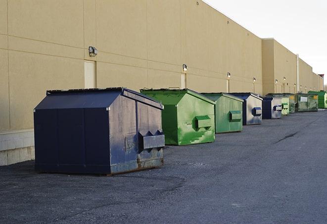 construction workers throw waste into a dumpster behind a building in Euless